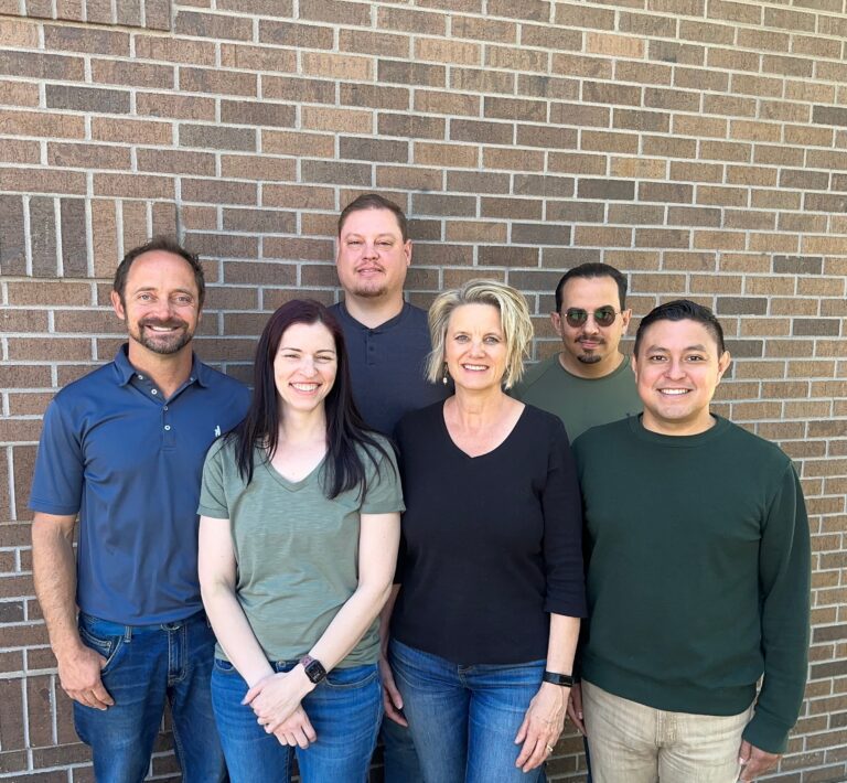 Thrive Roofing Co Team - 6 people standing in front of a brick wall