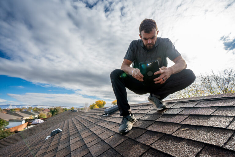 Man inspecting asphalt roof
